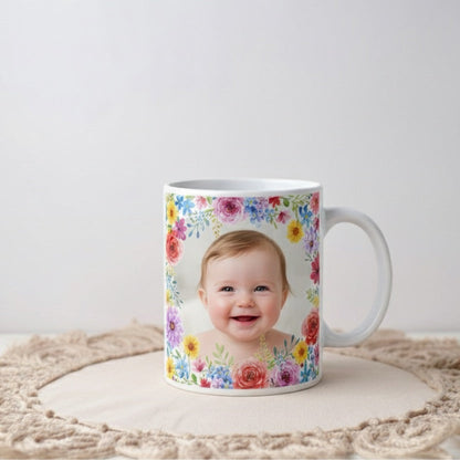 Mug with floral design and a baby's face on a white surface