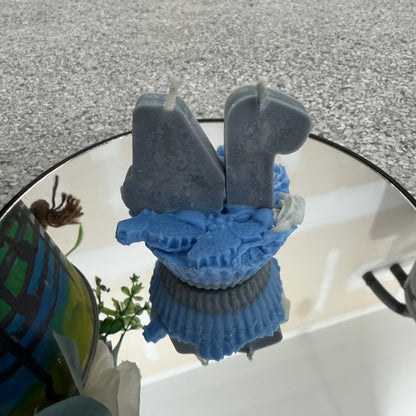 Blue and gray silicone mold on a reflective surface with a blurred background