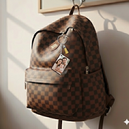 Brown checkered backpack with a Personalized keychain photo tag on a wall