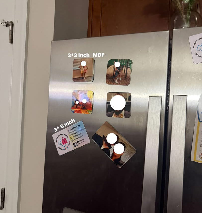 Stainless steel refrigerator with various magnets on a kitchen wall.
